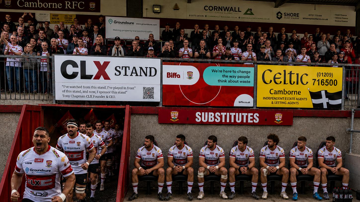 Players running out under the stand as the crowd applauds