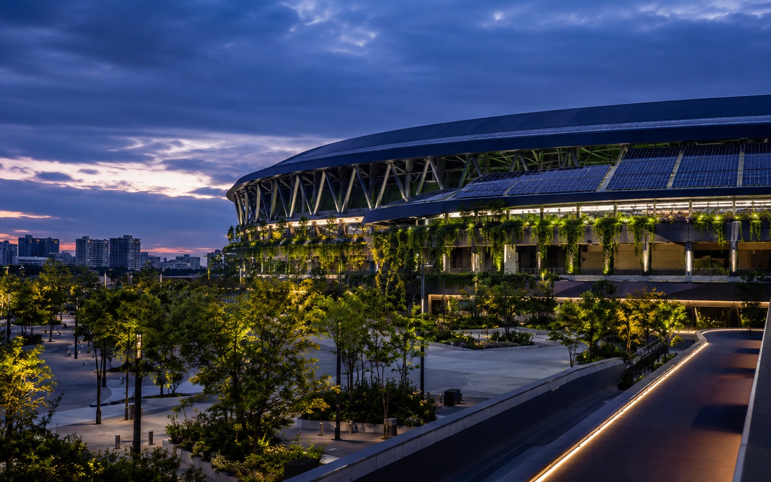 Sustainable venue with a living green wall lit at dusk